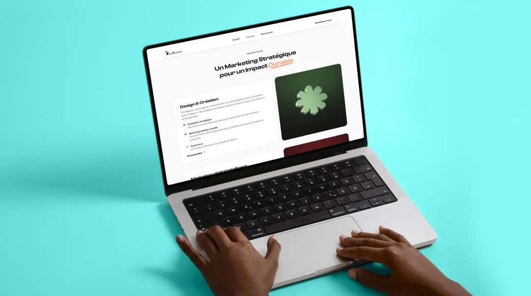 Hands typing on a laptop keyboard displaying a French webpage about strategic marketing with a green flower graphic on a turquoise background.